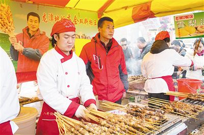 賣羊肉串攤位老板趙山（穿紅衣者）。新京報記者