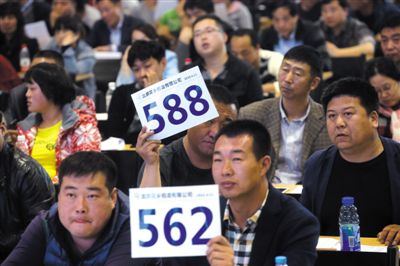 昨日，拍賣現(xiàn)場競拍者舉牌競拍。新京報記者