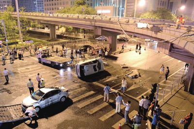路虎沖下國貿(mào)橋砸中一輛起亞轎車，橋上厚達幾十厘米的水泥護欄被撞斷，碎石四處散落，數(shù)十群眾在現(xiàn)場圍觀。