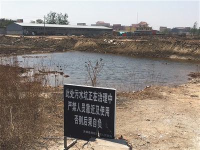 化肥廠滲坑的三分之一經(jīng)過(guò)治理，但水質(zhì)仍然呈黃褐色。