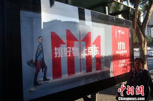 資料圖：11月1日，福州民眾從雙十一廣告牌前經(jīng)過。中新社記者 呂明 攝
