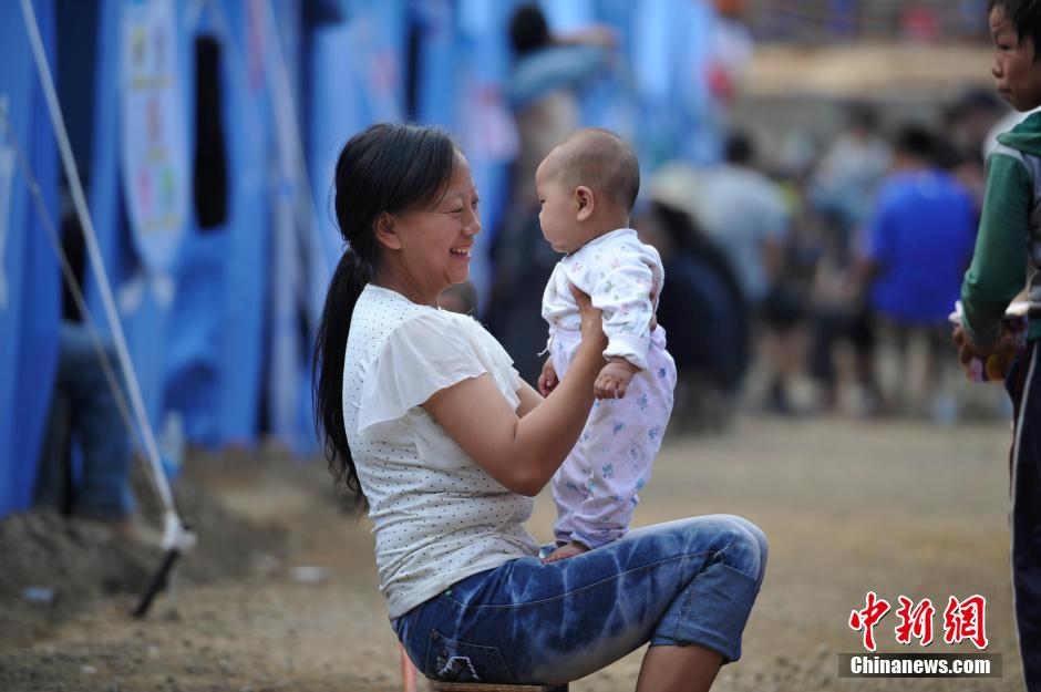 8月6日，一名年輕的母親在和孩子玩樂。