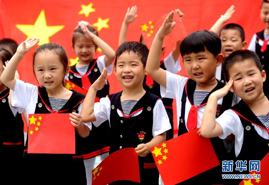  9月28日，安徽淮南市直機關(guān)幼兒園的小朋友在國旗前唱《國歌》，慶祝祖國65周歲生日。