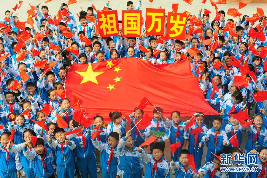 9月26日，安徽省阜陽市北城小學(xué)分校的學(xué)生與國旗合影。