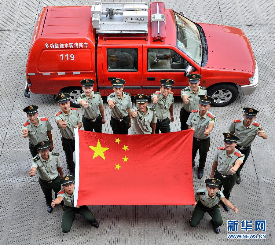  9月25日，武警浙江嘉興消防官兵與國旗合影。