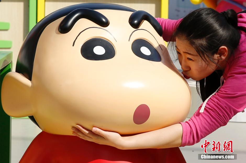 4月22日，游客與蠟筆小新合影。“蠟筆小新25周年紀(jì)念特展”日前在北京開展，吸引了不少市民游客。