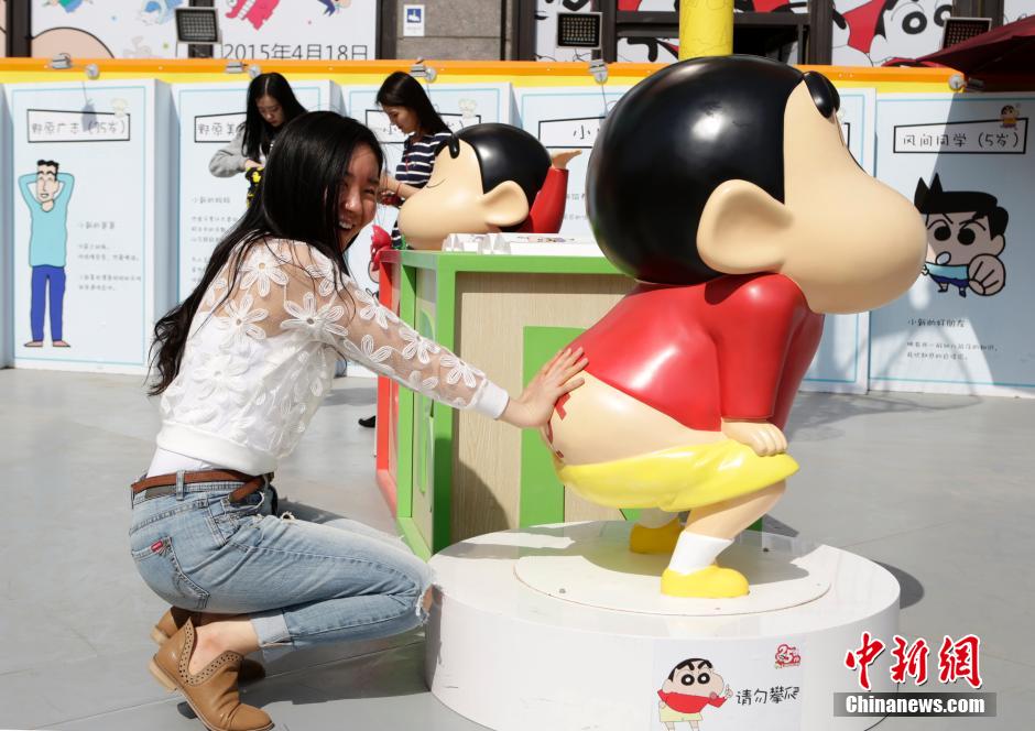 4月22日，游客與蠟筆小新合影?！跋灩P小新25周年紀(jì)念特展”日前在北京開展，吸引了不少市民游客。