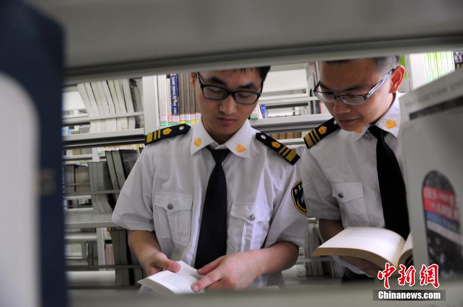 5月8日，武漢輕工大學(xué)圖書館保安吳濤與江力在圖書館交流學(xué)習(xí)。