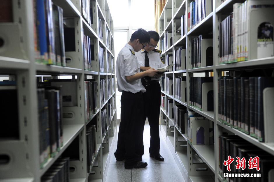 5月8日，武漢輕工大學(xué)保安吳濤與江力在圖書館交流學(xué)習(xí)。中新社發(fā) 張暢 攝