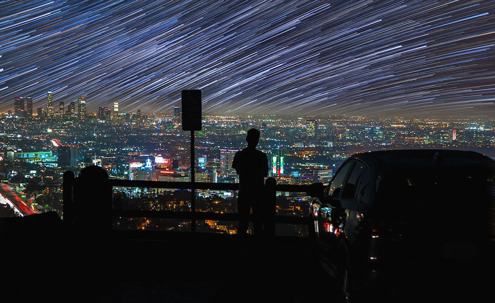 照片中，一名男子看著流星和隕星劃過天空。（網(wǎng)頁截圖）