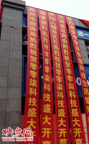 路邊一棟樓上懸掛著二三十條紅色條幅，全部是祝賀一家公司開(kāi)業(yè)的。