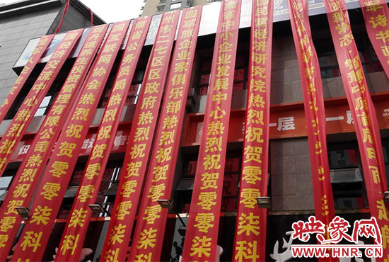 路邊一棟樓上懸掛著二三十條紅色條幅，全部是祝賀一家公司開(kāi)業(yè)的。