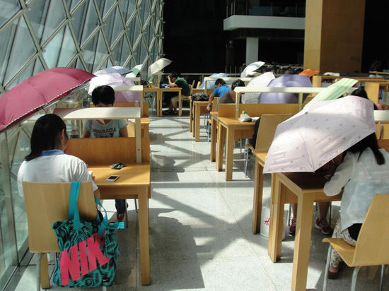 2015年8月2日，深圳圖書館，“太陽曬進(jìn)來很熱的，我們都要撐著傘讀書?！? complete=