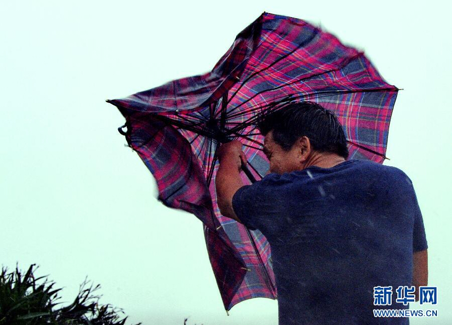 8月8日，福建省石獅市漁民在風雨中前行。