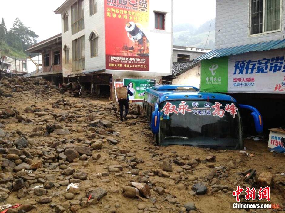 圖為山洪泥石流導(dǎo)沖進鄉(xiāng)鎮(zhèn)街道，導(dǎo)致客車被埋。