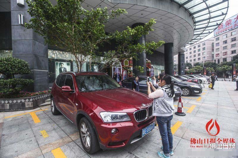 一輛停在停車(chē)位上的寶馬轎車(chē)，被墜落的樹(shù)枝砸中，樹(shù)枝徑直插入車(chē)內(nèi)，現(xiàn)場(chǎng)引發(fā)不少市民圍觀拍照。