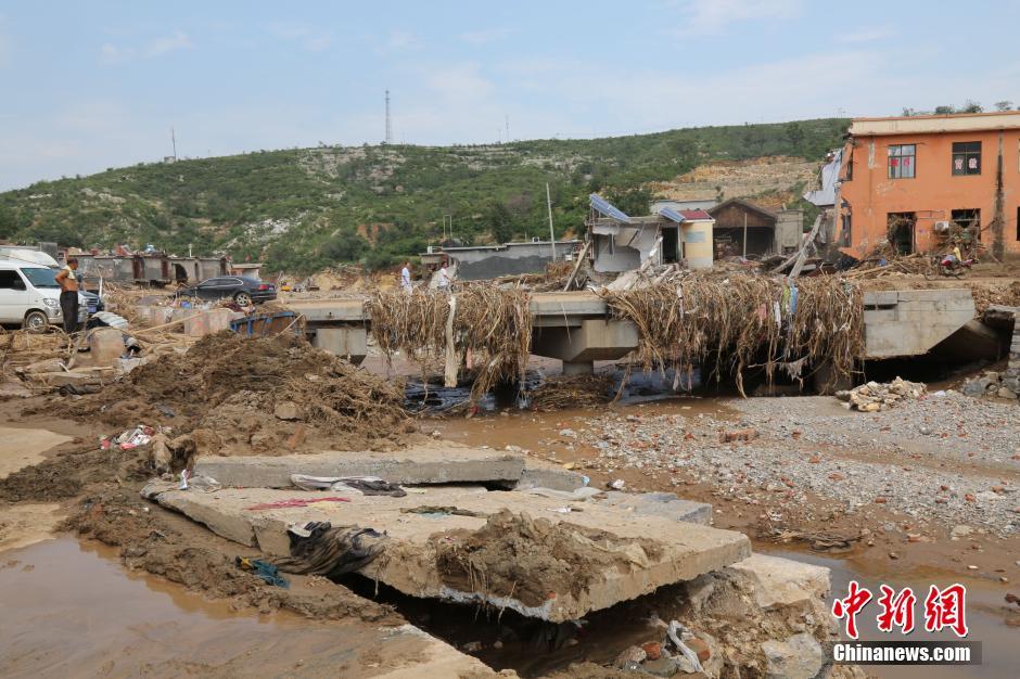 圖為洪水過后，坍塌的橋梁上遺落大量雜草。
