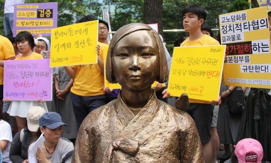 7月2日，在韓國首爾的日本駐韓國大使館前，民眾在慰安婦少女像旁手持標(biāo)語參加抗議活動。