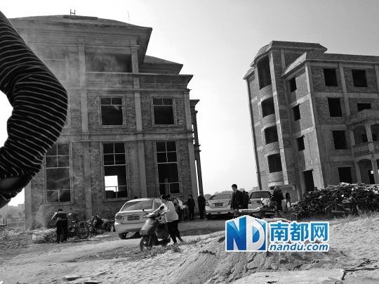 兩棟被舉報的違建樓下昨日一度聚集了超過百人，城管離開后逐漸散去。南都記者張志韜實習生宋超攝