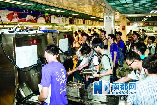 昨日，華南理工大學(xué)一食堂內(nèi)，學(xué)生們正在使用新安裝的自動(dòng)打飯機(jī)打飯。中新社發(fā)