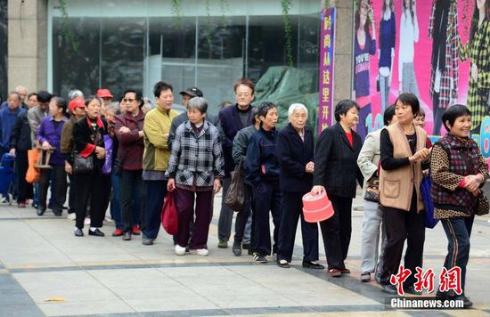 圖為10月28日，在江西九江市一家羊絨皮草服裝服飾博覽會(huì)現(xiàn)場，老人們正在頂著寒風(fēng)排隊(duì)等待領(lǐng)取10元代金劵。