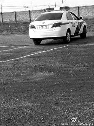 一輛車牌號 為“ 陜DD173”的制式警車停在一個劃著白線的場地上，車身標(biāo)有“司法”字樣