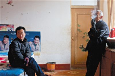 父親抽煙，兒子不語。逃跑的越南新娘，給袁迎賓父子帶來的是失落。新京報記者 周崗峰 攝