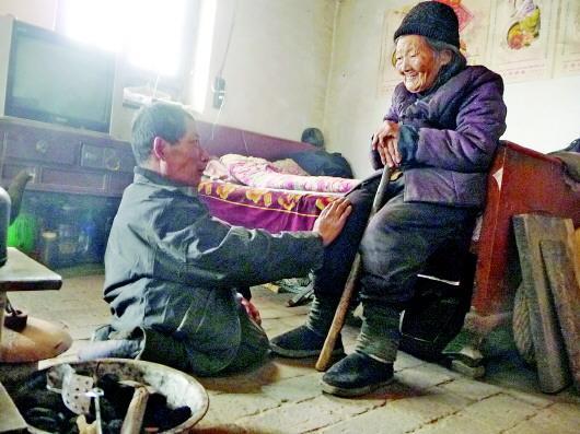 52歲的劉蘭山每天靠爬行照顧90歲的老母親。孫國(guó)祥 攝