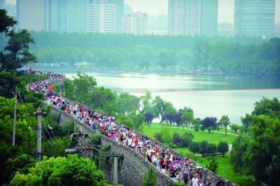 　　昨天,數(shù)萬南京市民參加“環(huán)城七十里”徒步走,圖為解放門城墻上密集的人群。 本版攝影 實(shí)習(xí)生 王甜