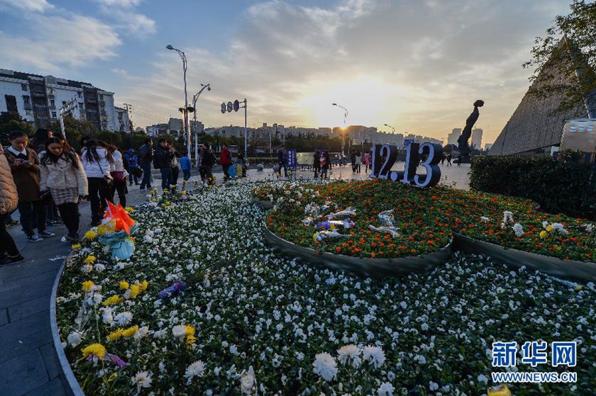 12月14日,觀眾在侵華日軍南京大屠殺遇難同胞紀(jì)念館前的“12·13”花壇上擺放鮮花祭奠遇難同胞。新華社記者 沈鵬 攝