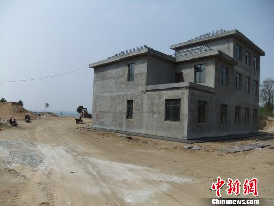 鴨河水庫庫區(qū)邊的新建別墅，一面墻上寫著“拆”，另一邊在加緊施工。吳揚(yáng)　攝